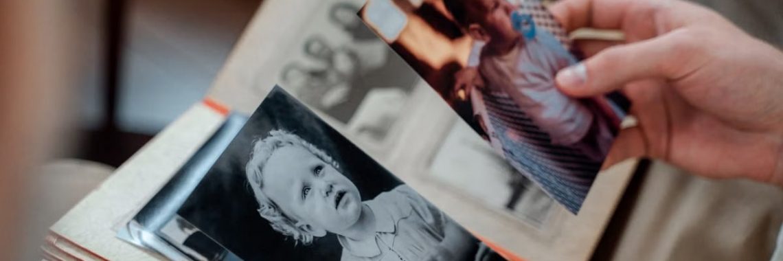 Close-up of hands examining nostalgic family photos in an album.